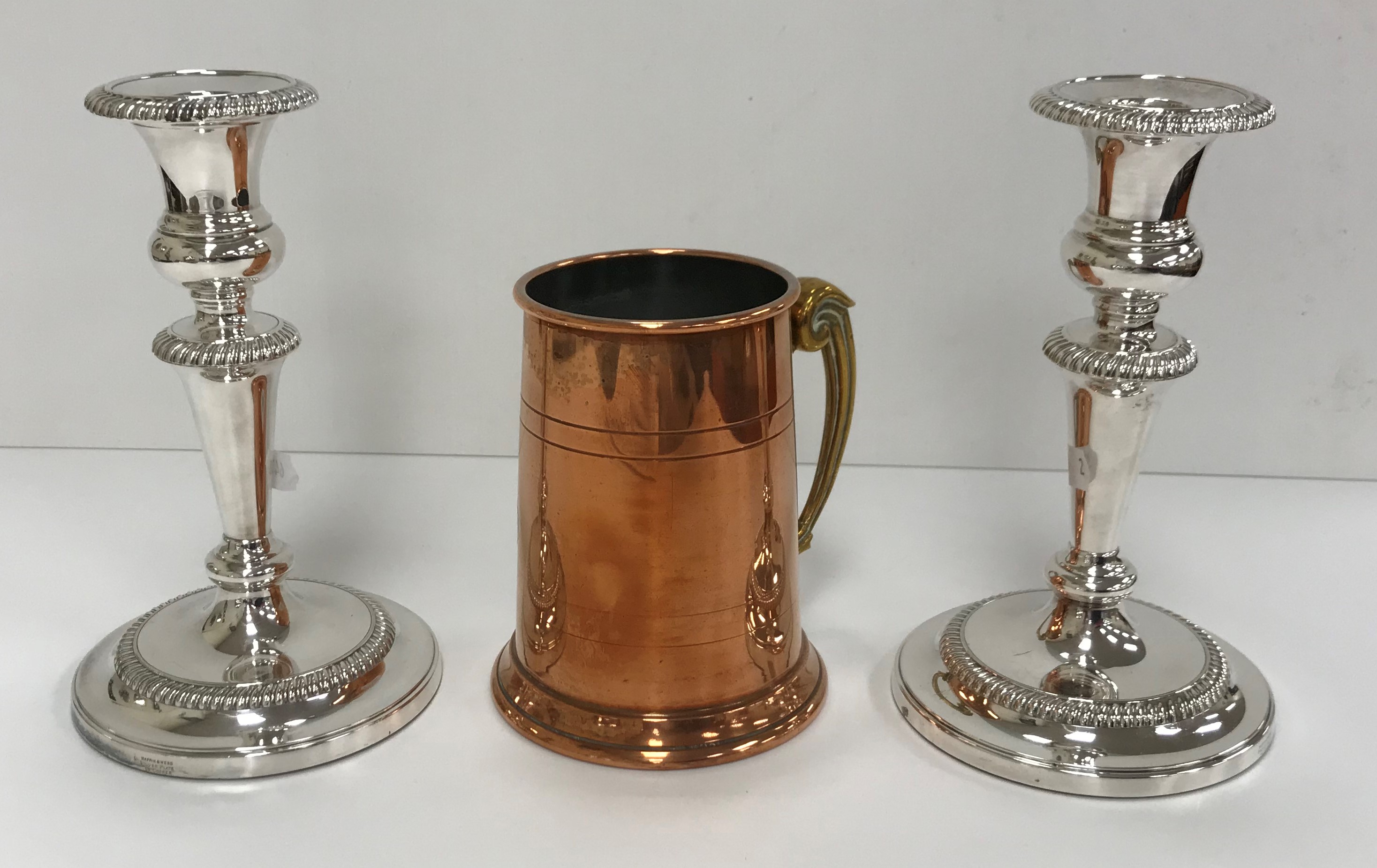 A box containing assorted plated and copper wares to include candlesticks, tastevin, cutlery,