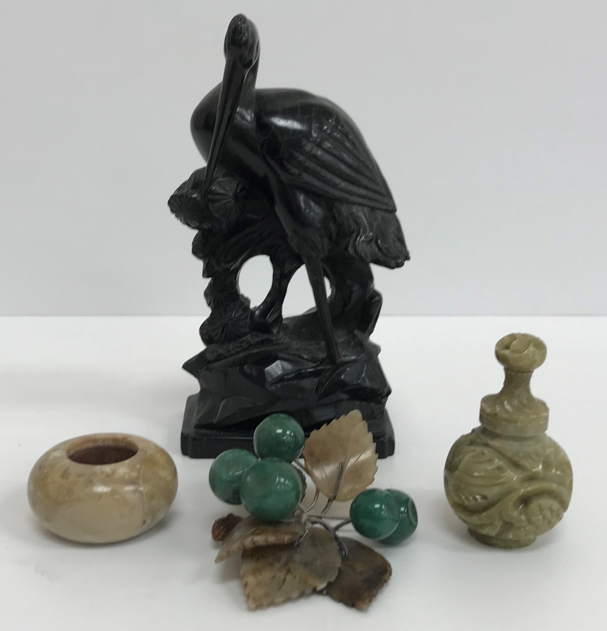 A box of Chinese soap stone items including a pair of foliate decorated bookends, various bowls,