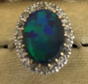 An 18 carat white gold cabochon opal and diamond set cluster ring, size O, 5.