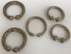 Two pairs of white metal slave bangles / bracelets, together with another similar, 13.