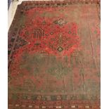 An Ushak design carpet, the central panel set with stylised foliate decoration on a red ground,