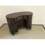 A reproduction mahogany cross-banded kidney-shaped dressing table in the Regency style,