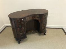 A reproduction mahogany cross-banded kidney-shaped dressing table in the Regency style,