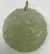 A Chinese pale jade pendant decorated with dragon and phoenix,