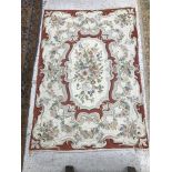 A crewel work panel, the central panel set with floral spray on a red ground, within a red,