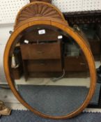A late Victorian oak framed oval wall mirror with sunburst carved top, over a bevel edged plate,