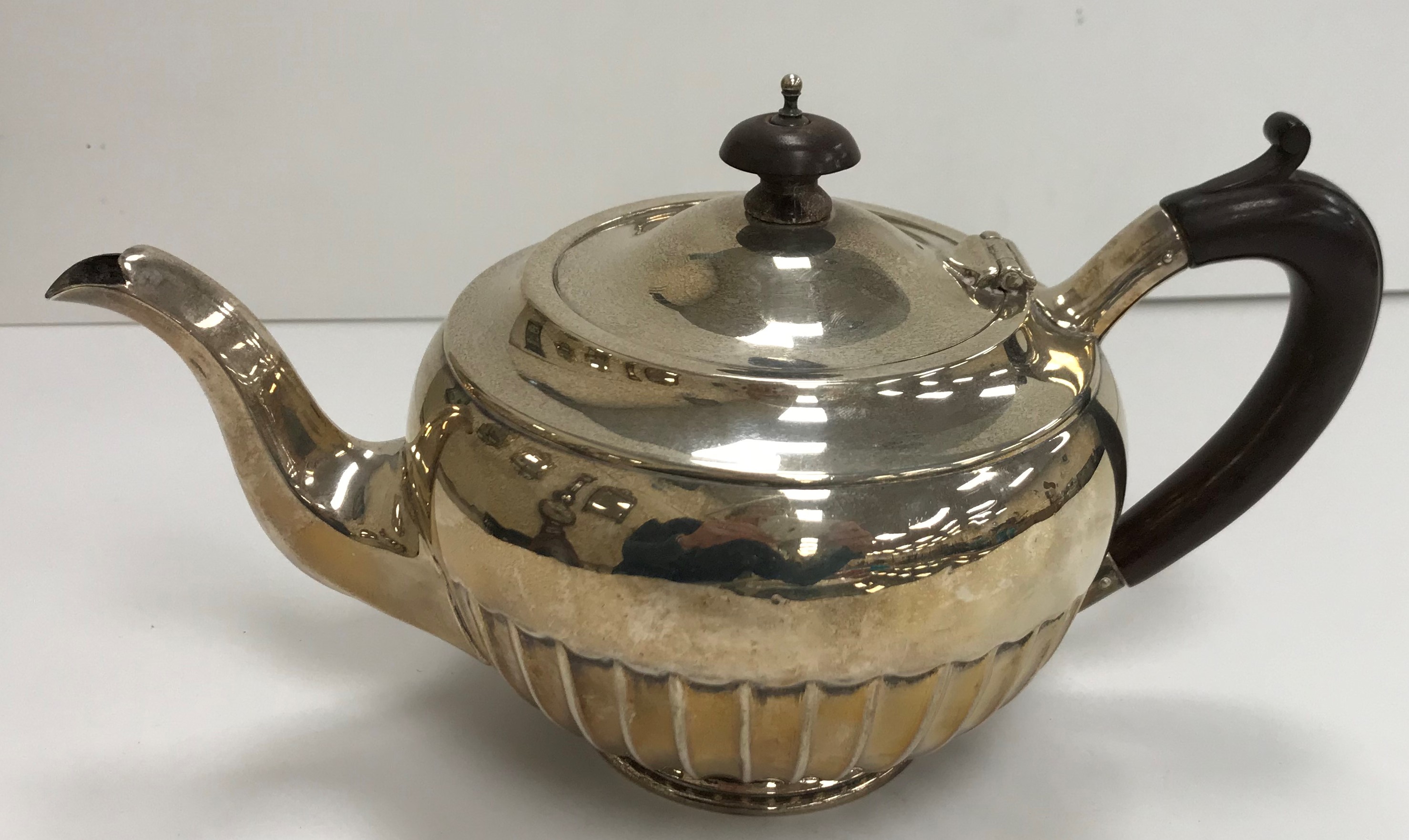 A George V silver teapot of circular form, with fluted bottom half,