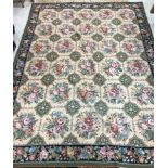 An Aubusson carpet, the central panel set with all-over floral decoration on a cream ground,