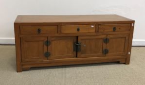 A Chinese cherry wood dwarf chest, the plain top over three small drawers and two cupboard doors,