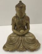 A Chinese carved soapstone figure of a "Seated Buddha with peach in hand, in lotus position",