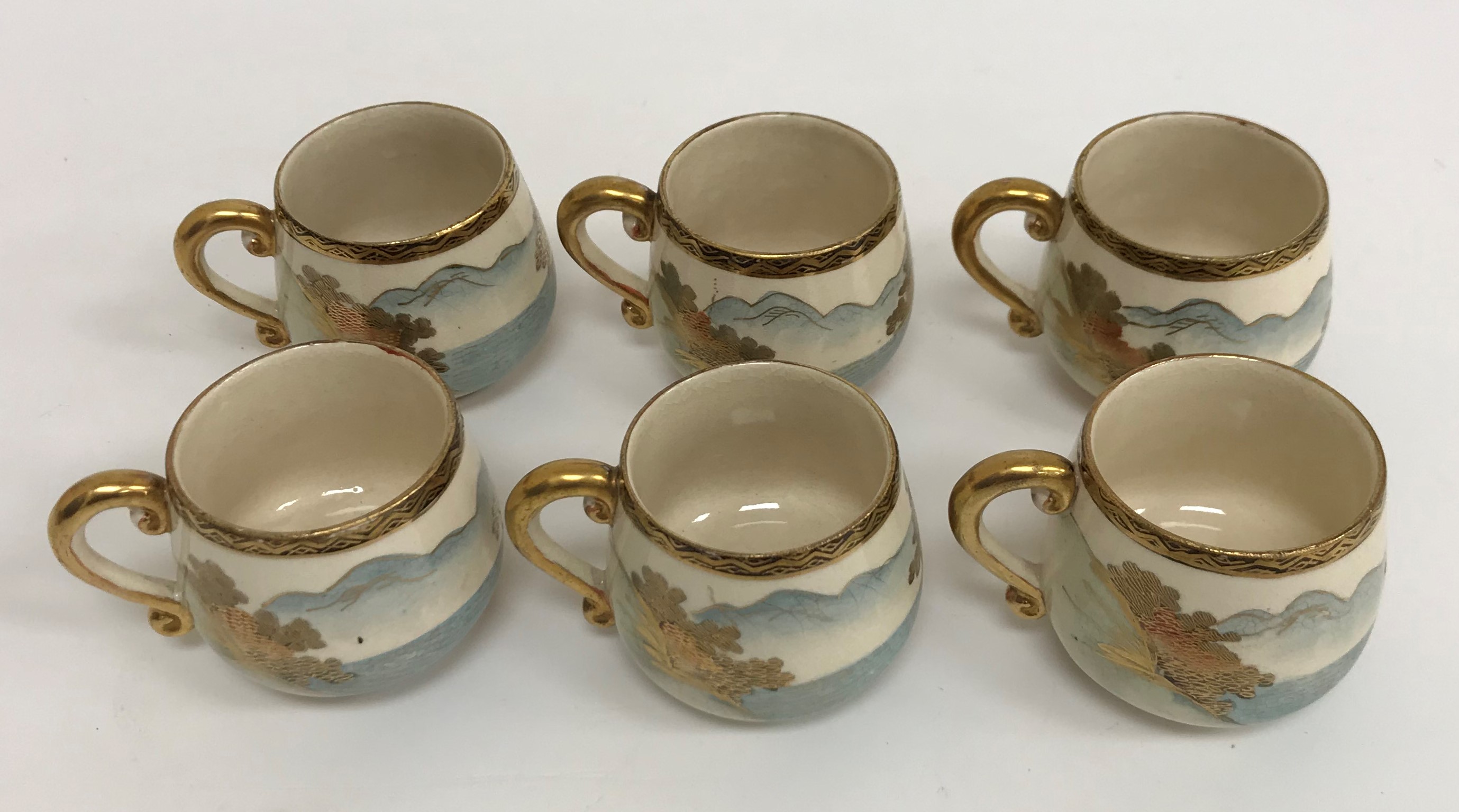 A Meiji period Satsuma pottery set of six cups and saucers with figural and costal landscape - Image 2 of 4