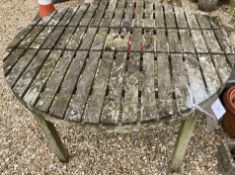 A weathered teak circular garden table,