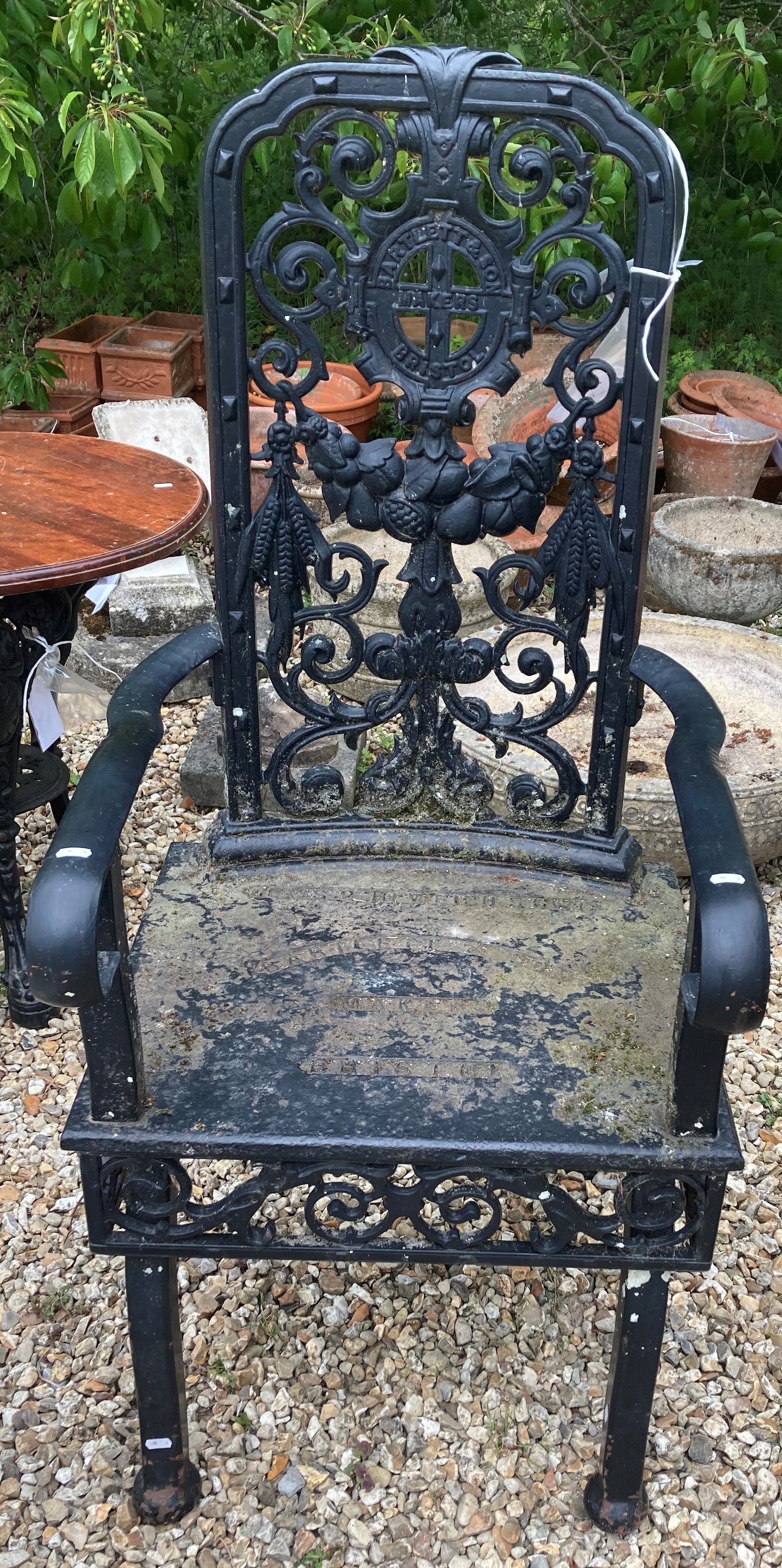 A black wrought iron high backed arm cha