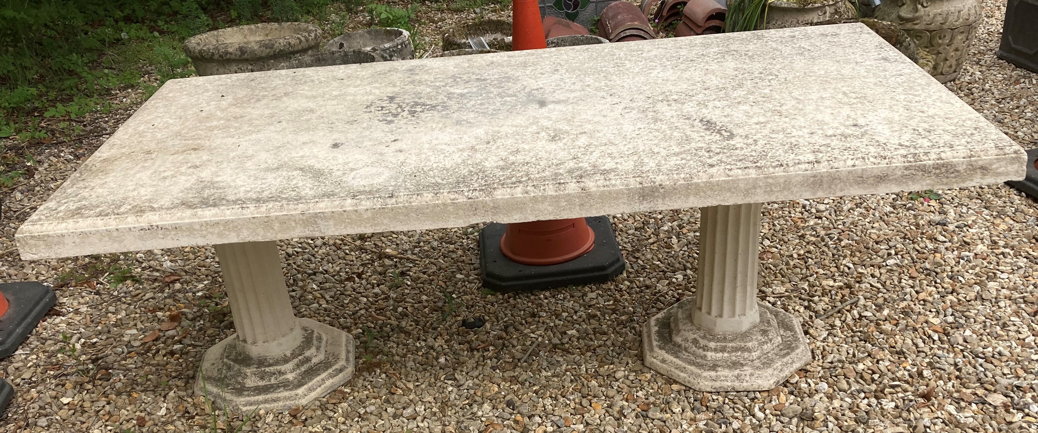 A cast concrete garden table raised on t