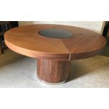 A modern walnut circular dining table wi