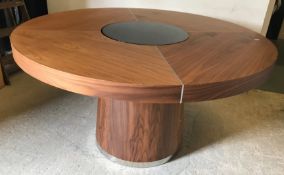 A modern walnut circular dining table wi