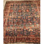 A Persian carpet, the central panel set with repeating stylised floral decoration, on a blue ground,