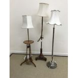 A collection of three various standard lamps including a mahogany pole screen conversion,