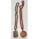 A Chinese agate bead necklace with carved circular pendant and silver and filigree work clasp,