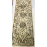 A Tabriz style runner, the central panel set with three repeating medallions on a cream ground,