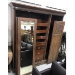 A late Victorian walnut wardrobe compactum with foliate carved doors flanking a central mirrored