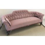 A Victorian buttoned pale pink upholstered scroll arm sofa on Gothic style beaded decorated
