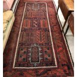 A fine vintage Belouch carpet, the central panel set with rectangular tile motifs in red,