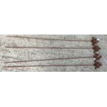 A collection of four metal plant stakes with rust style patination,