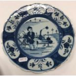 An 18th Century Dutch Delft chinoiserie decorated plate with figure seated upon a table, with flask,