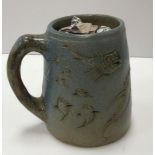 A late 19th Century Martin Brothers pottery cylindrical tapering mug with fish / sea beasts