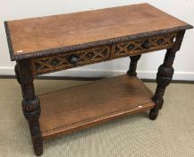 A Victorian style carved oak side table, the plain top with carved edge above two carved drawers,