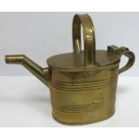 A collection of three brass watering cans/hot water jugs together with a pewter twin handled bowl