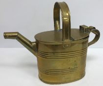 A collection of three brass watering cans/hot water jugs together with a pewter twin handled bowl