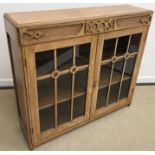 A mid 20th Century oak two door glazed bookcase, the top carved with the word "Books",