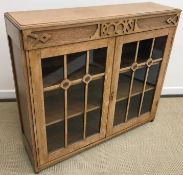 A mid 20th Century oak two door glazed bookcase, the top carved with the word "Books",