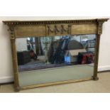 An early 19th Century gilt framed overmantel mirror with beaded decoration to top and moulded lion