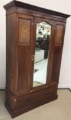An Edwardian mahogany single mirror door wardrobe, the single door above a single drawer,