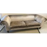 A modern Chesterfield sofa with taupe velvet upholstery, raised on turned and ringed front legs,