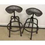 A pair of modern stools as tractor seats of adjustable height,