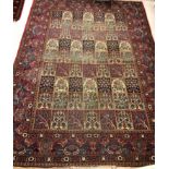 A Persian carpet, the burgundy ground set with repeating tiled decoration,