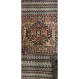 A Turkish prayer rug, the central panel set with repeating motifs on a dark blue ground,