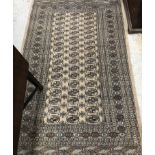 A Tekke Bokhara rug, the central panel set with three rows of repeating elephant foot medallions,