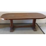 An Arts & Crafts style teak table, the panelled top with rounded corners,