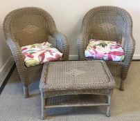 A modern cane effect conservatory set comprising two tub chairs and a table,