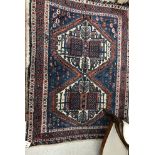 An Afshar rug, the central panel set with two joined medallions on a blue ground, with hook motifs,