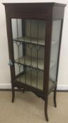 An Edwardian mahogany and inlaid display cabinet with leaded glazed door, raised on swept legs,