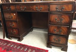 A reproduction mahogany kneehole desk,