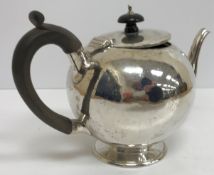 A Victorian silver bullet-shaped teapot with ebonised handle and finial (by Charles Stuart Harris,