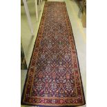 A Persian runner, the central panel set with all over floral decoration on a navy ground,