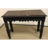 A 19th Century carved oak side table, the plain top above carved edge and frieze with shaped apron,